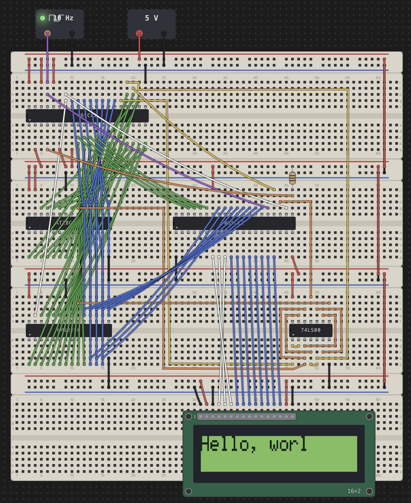 A Chip Hippo circuit: a W65C02 CPU with an AT28C EEPROM and an HM62256 SRAM across four stacked breadboards, fed by a 5 V supply and a 10 Hz clock, driving a 16x2 character LCD part-way through printing Hello, world.